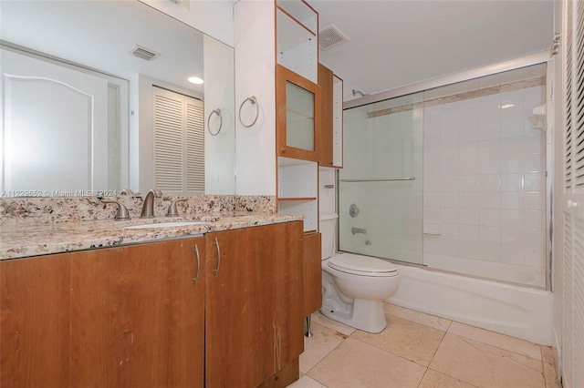 full bathroom featuring vanity, bath / shower combo with glass door, toilet, and tile patterned flooring