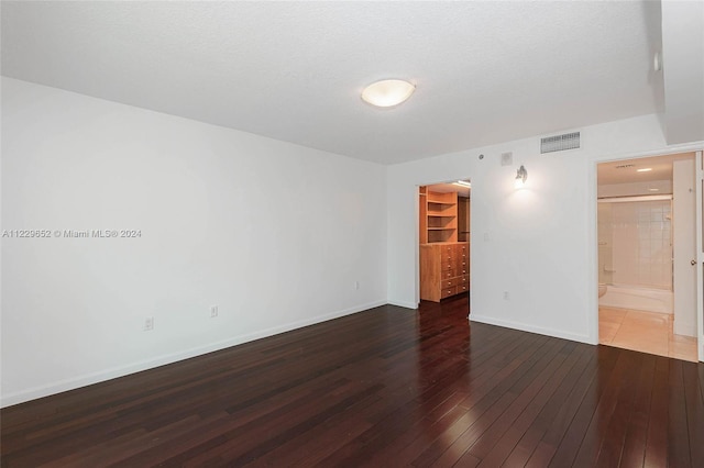 empty room featuring dark wood-type flooring and a textured ceiling