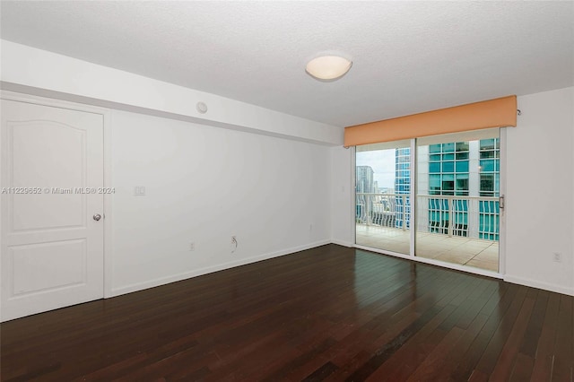 spare room featuring a textured ceiling and wood-type flooring