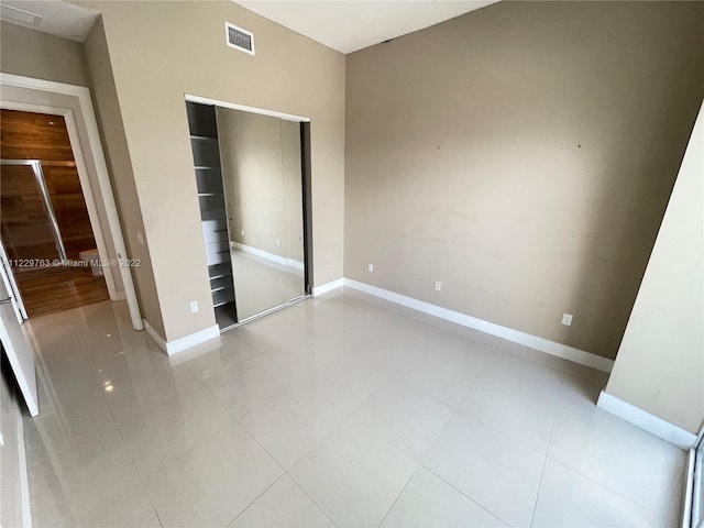 unfurnished bedroom with a closet and light tile floors