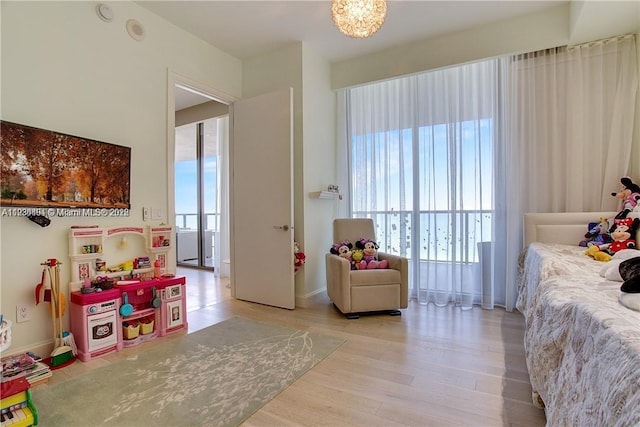 interior space featuring light hardwood / wood-style floors, multiple windows, and an inviting chandelier