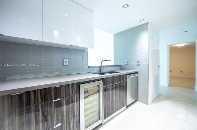 kitchen featuring sink, stainless steel dishwasher, white cabinets, and wine cooler