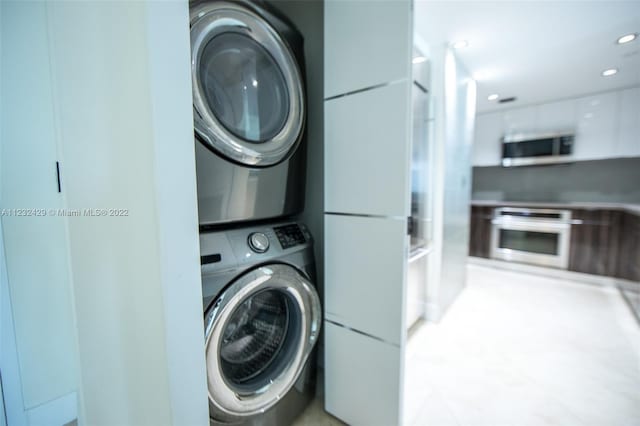 clothes washing area featuring stacked washer and clothes dryer