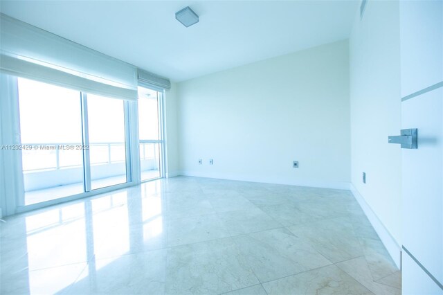 tiled empty room with floor to ceiling windows