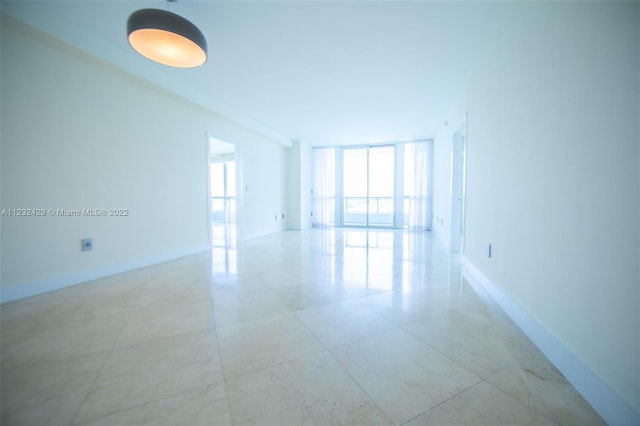 tiled empty room featuring expansive windows