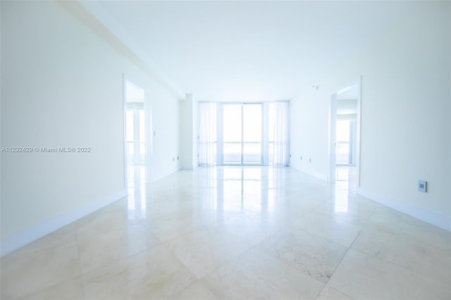 tiled spare room featuring expansive windows