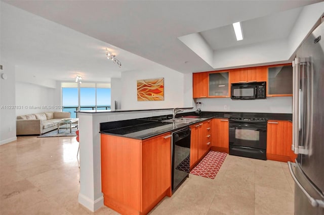 kitchen featuring kitchen peninsula, black appliances, a wall of windows, sink, and light tile floors