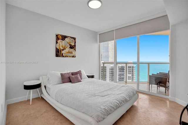 bedroom featuring a water view, access to exterior, expansive windows, and light tile floors