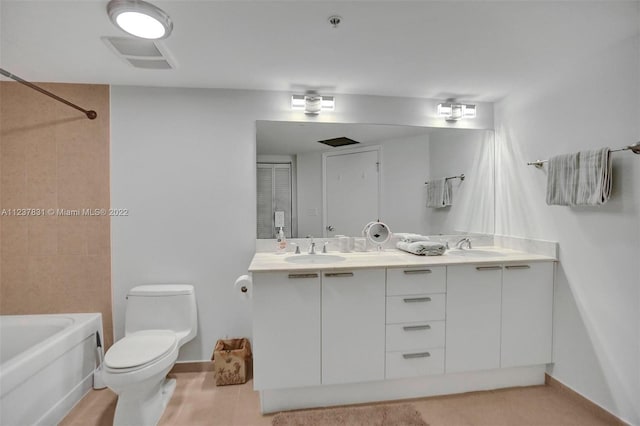 full bathroom featuring double sink, vanity with extensive cabinet space, toilet, and tiled shower / bath