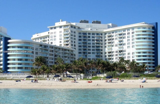 view of swimming pool with a beach view and a water view