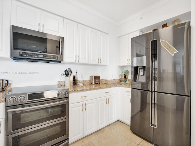 kitchen featuring light stone countertops, appliances with stainless steel finishes, and white cabinetry