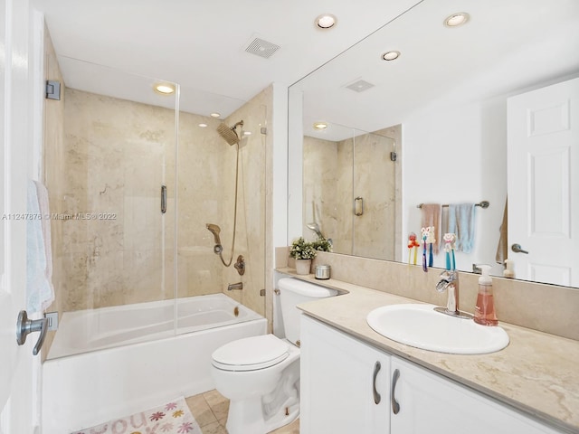 full bathroom with enclosed tub / shower combo, toilet, large vanity, and tile flooring