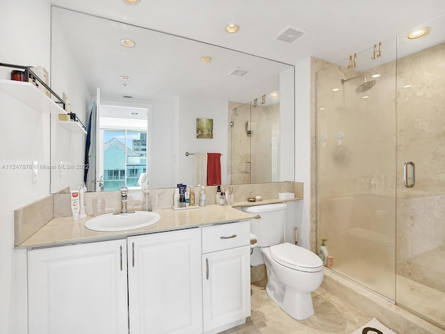 bathroom featuring toilet, tile floors, a shower with shower door, and vanity