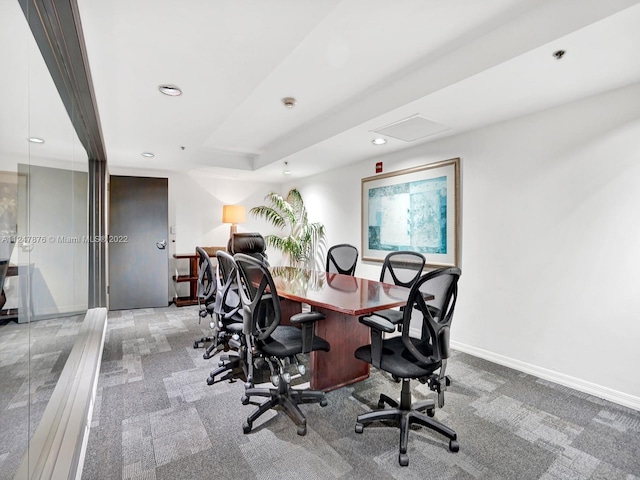 office space with light carpet and a tray ceiling