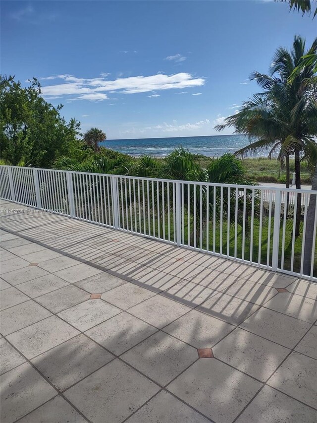 view of patio featuring a water view and a balcony