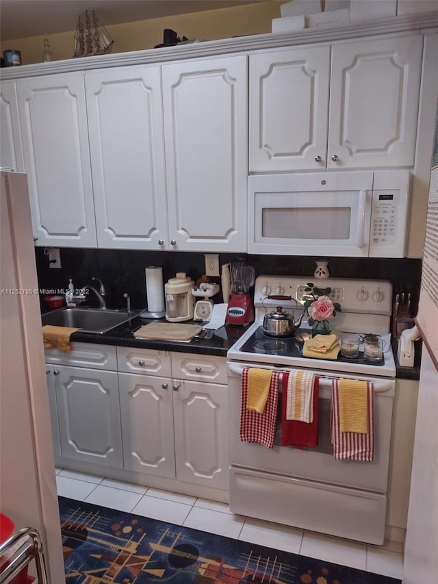 kitchen featuring light tile floors, white appliances, white cabinetry, and sink