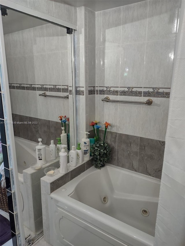 bathroom featuring tile walls and a shower with shower door