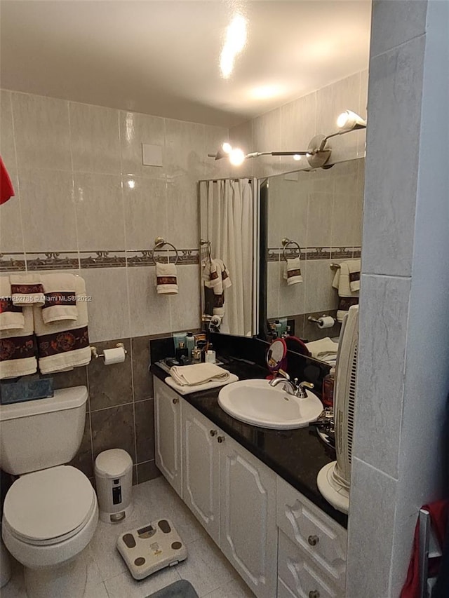 bathroom with vanity, tile floors, toilet, and tile walls