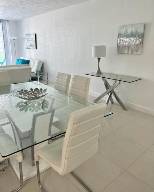 dining area with light tile floors and a textured ceiling