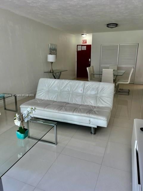 living room featuring light tile floors and a textured ceiling