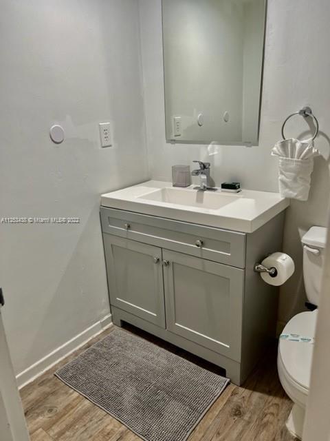 bathroom featuring vanity, toilet, and hardwood / wood-style flooring