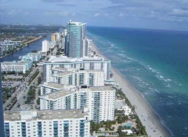 birds eye view of property with a water view and a view of the beach