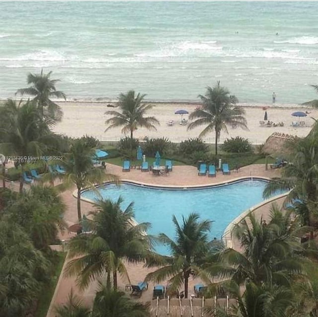 view of swimming pool with a view of the beach and a water view