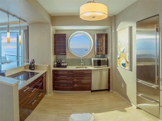 kitchen with hanging light fixtures, sink, and stainless steel appliances