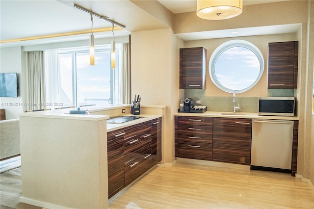 kitchen featuring hanging light fixtures, sink, appliances with stainless steel finishes, and a wealth of natural light