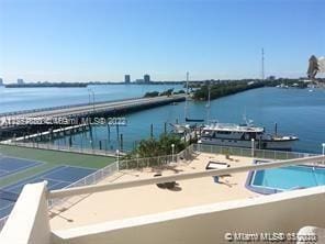 dock area featuring a water view and a fenced in pool