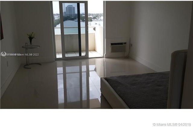 bedroom with light tile floors and an AC wall unit