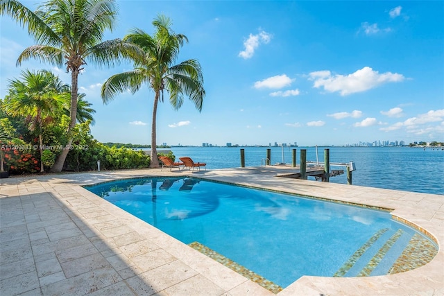 view of pool with a dock, a water view, and a patio