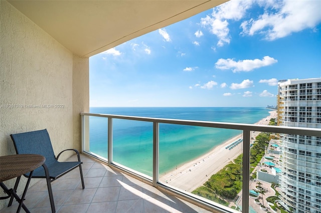 balcony with a water view and a view of the beach