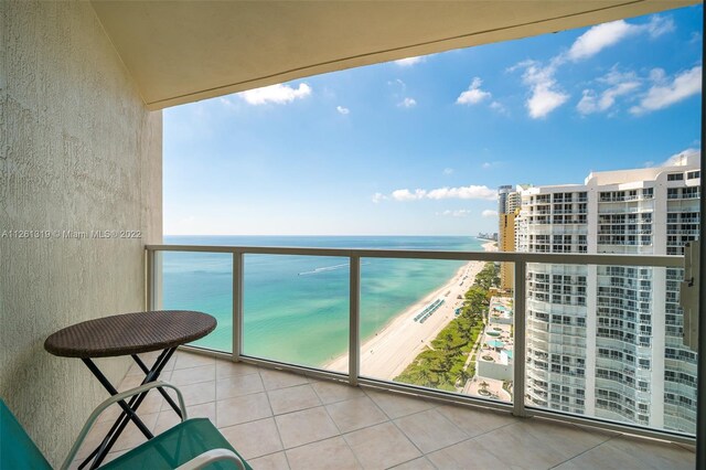 balcony featuring a water view and a view of the beach