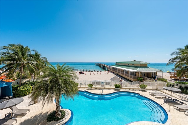 view of swimming pool with a water view and a patio