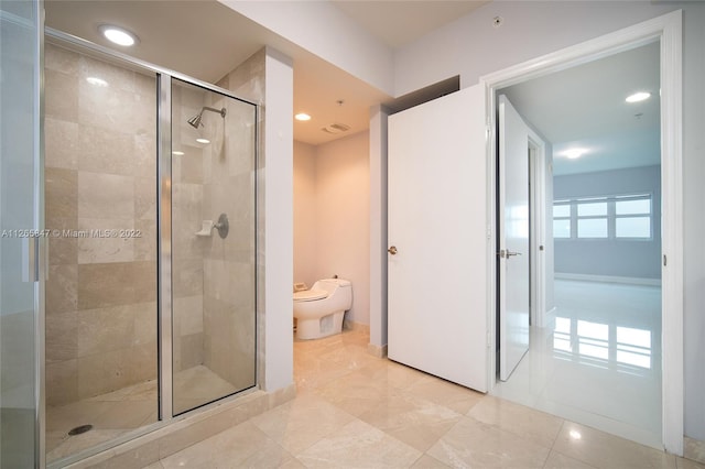 bathroom featuring toilet, a shower with shower door, and tile flooring