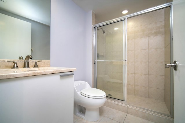 bathroom featuring oversized vanity, toilet, tile floors, and a shower with shower door