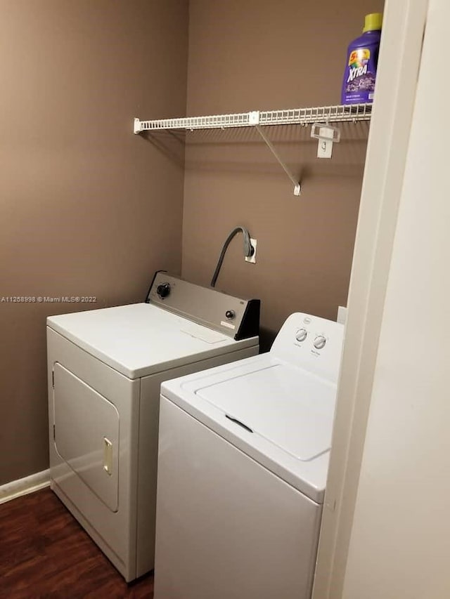 clothes washing area with separate washer and dryer, hookup for an electric dryer, and dark hardwood / wood-style flooring