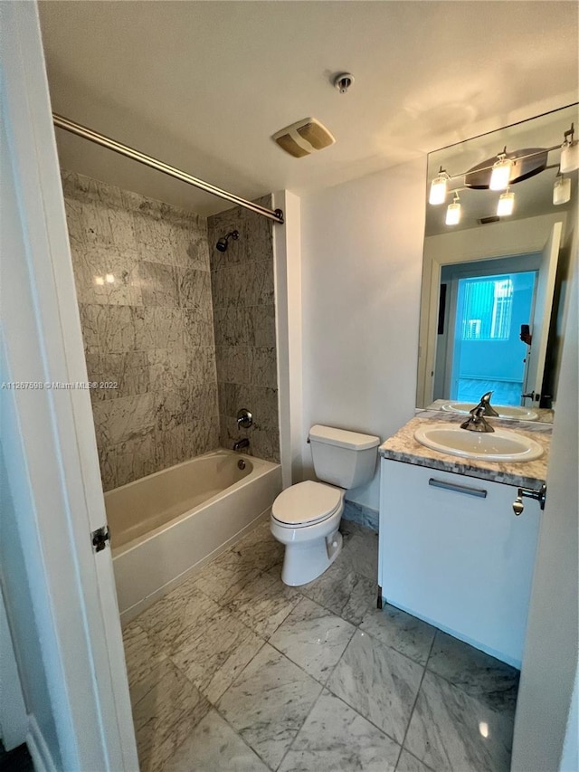 full bathroom featuring oversized vanity, tiled shower / bath combo, toilet, and tile flooring