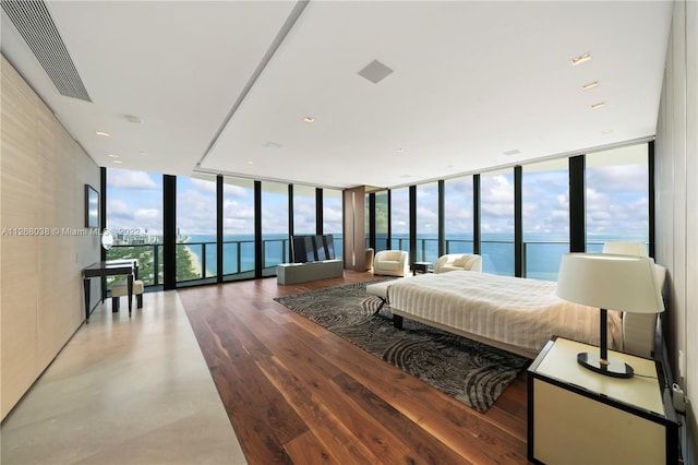 bedroom with a water view, a wall of windows, access to exterior, and hardwood / wood-style flooring