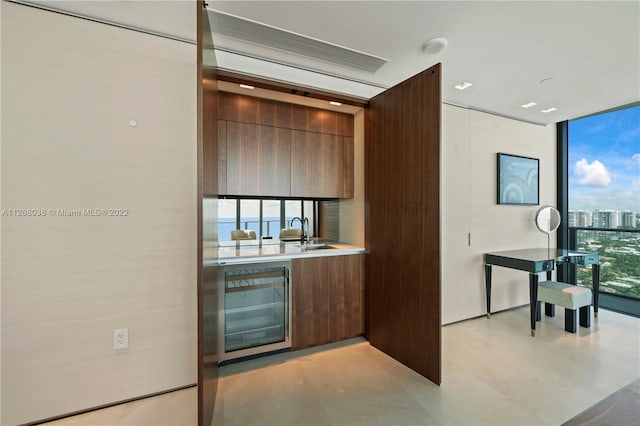 bar featuring beverage cooler, floor to ceiling windows, and sink