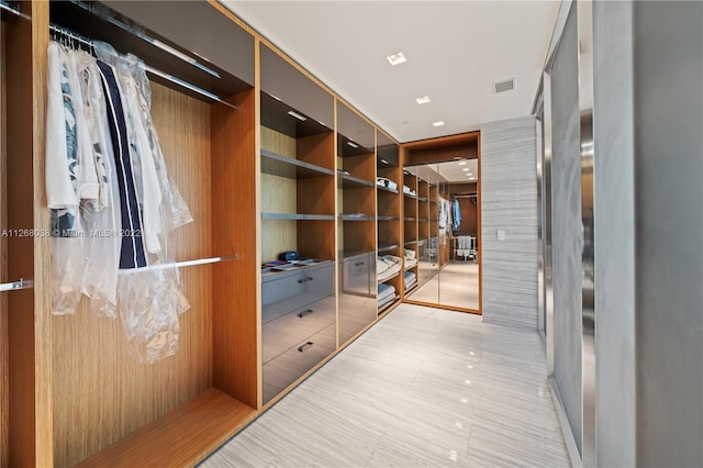 walk in closet with light tile flooring