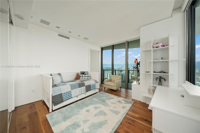 bedroom with access to outside, floor to ceiling windows, and dark hardwood / wood-style floors