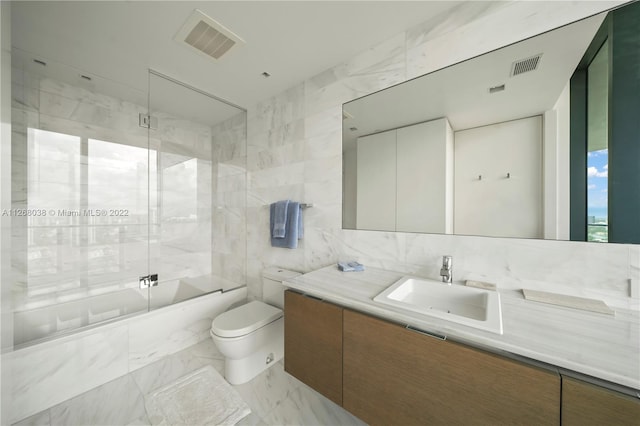 full bathroom with toilet, oversized vanity, tile walls, combined bath / shower with glass door, and tile flooring