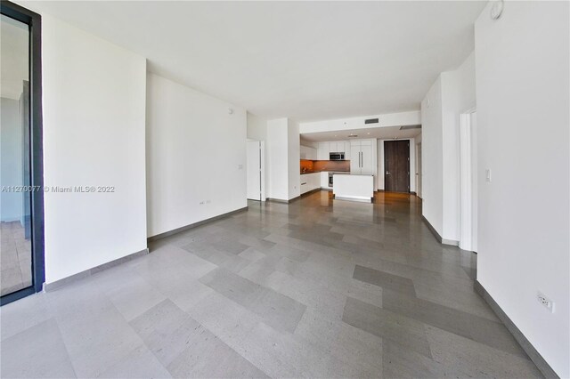 unfurnished living room featuring visible vents, baseboards, and tile patterned floors