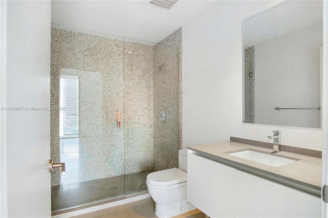 bathroom featuring a stall shower, visible vents, vanity, and toilet