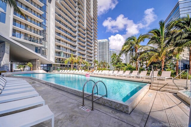 community pool with a city view and a patio