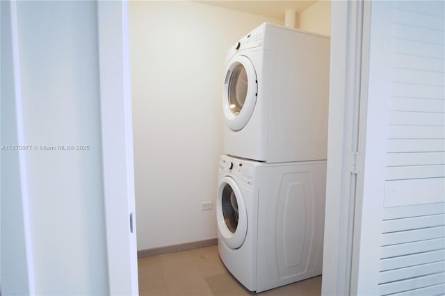 laundry room with stacked washer and dryer, laundry area, and baseboards