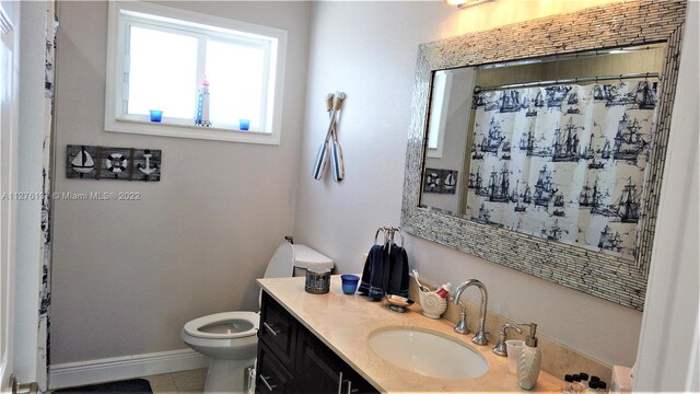 bathroom featuring toilet, large vanity, and tile flooring