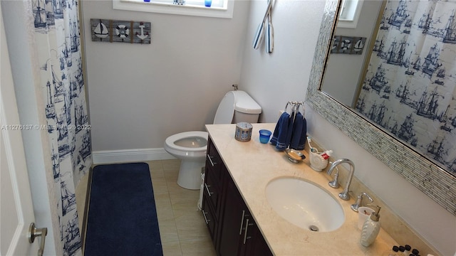 bathroom with toilet, tile floors, and vanity with extensive cabinet space